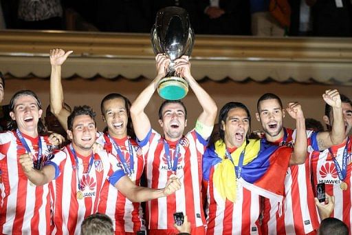 Atletico Madrid's players celebrate with the trophy